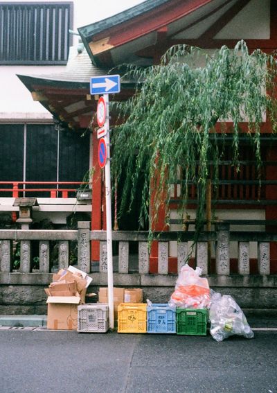 Trash is neatly arranged at the base of a sign post on the street side.