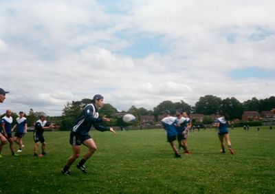 A boy wearing a blue and white Chinese Taipei hoodie throws a pass to a teammate off screen.