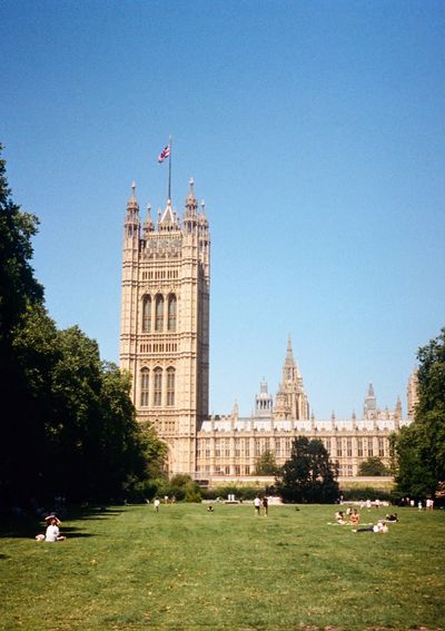 People sunbathing in a park outside the Houses of Parliament in London.