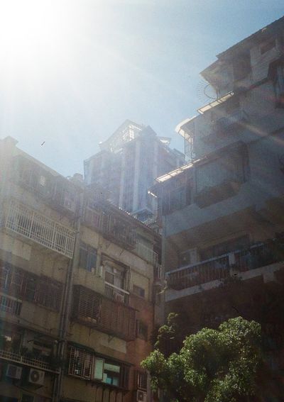 A new high-rise apartment building is juxtaposed between two older low-rise residential apartments.