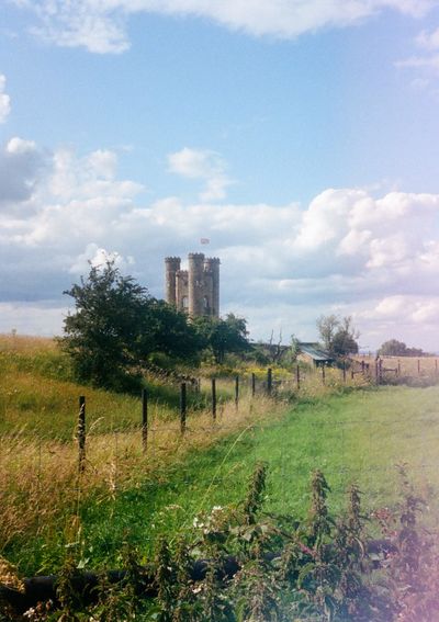 A stone tower stands in a field.