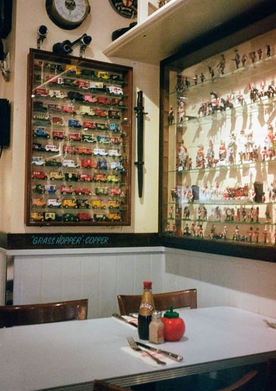 Sauce bottles sit neatly on a table. Retro figurines and trinkits line the wall.