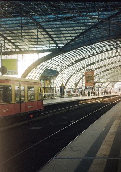 A red and white train is stopped at a platform in the sunshine. The train is only partially in the shot.