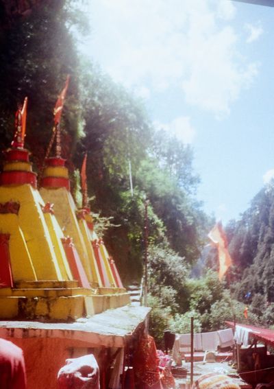 Yellow and red conical shaped roofs appear in the front of the picture. A sunlit valley is visible in the distant background.