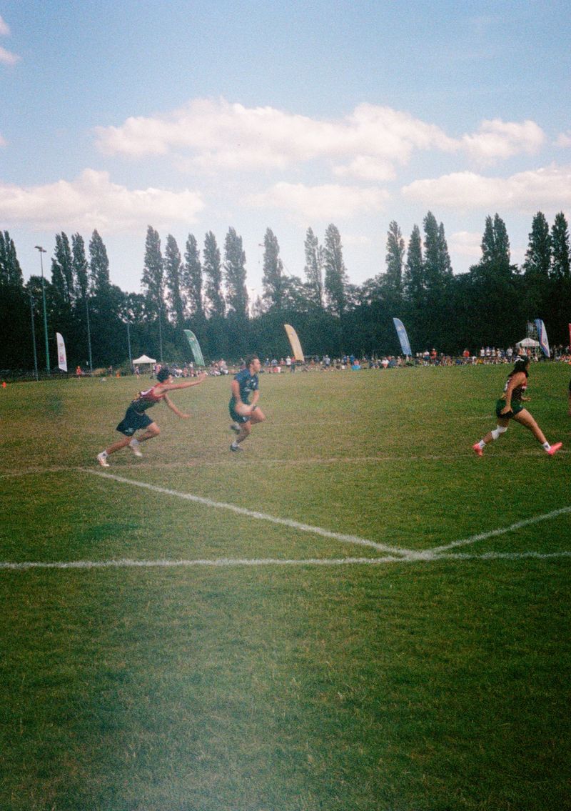 A boy in a blue Scotland shirt shapes to pass a rugby ball. A young player in a red and yellow Philippines vest reaches out to make a touch.