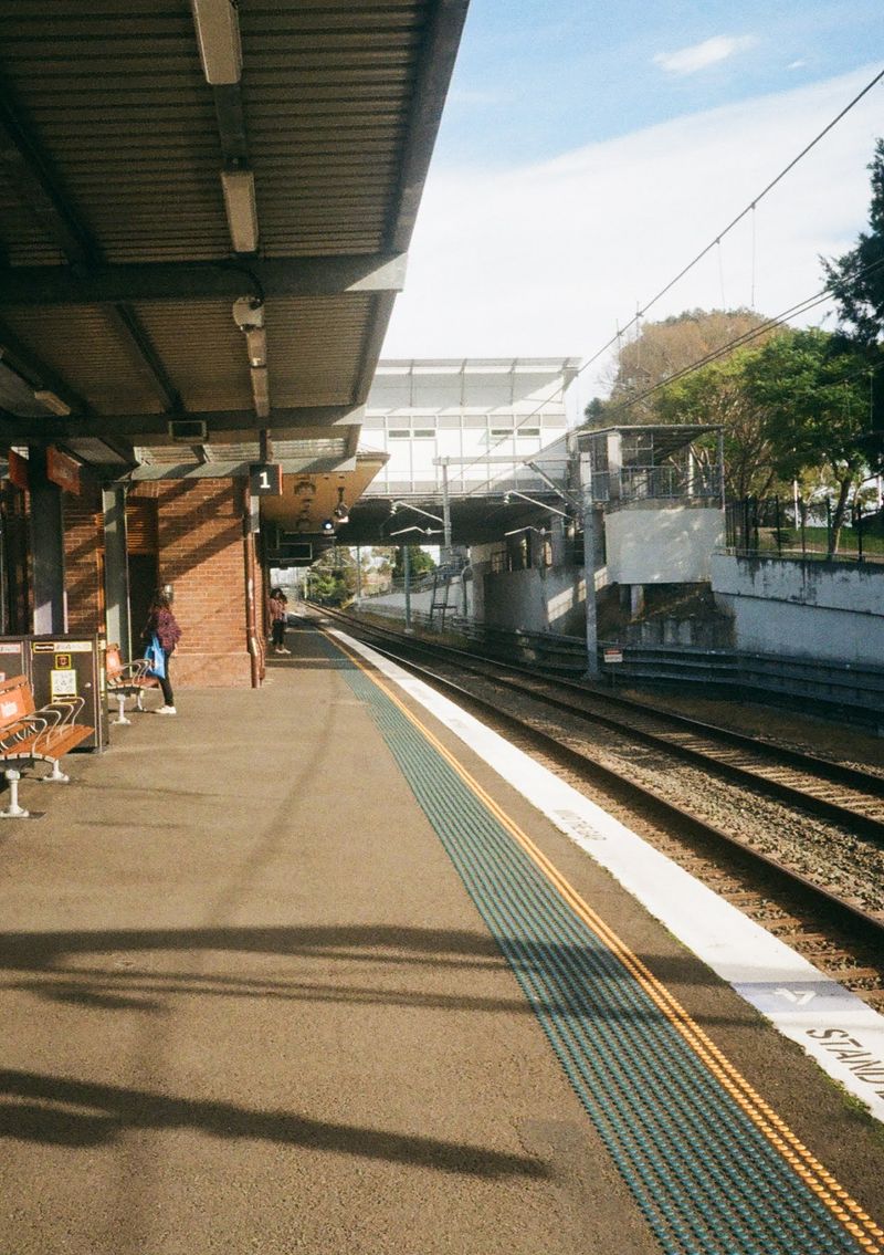 Looking down a partially covered train platform. The tracks are on the right of the shot, and the largely empty platform is in the center.