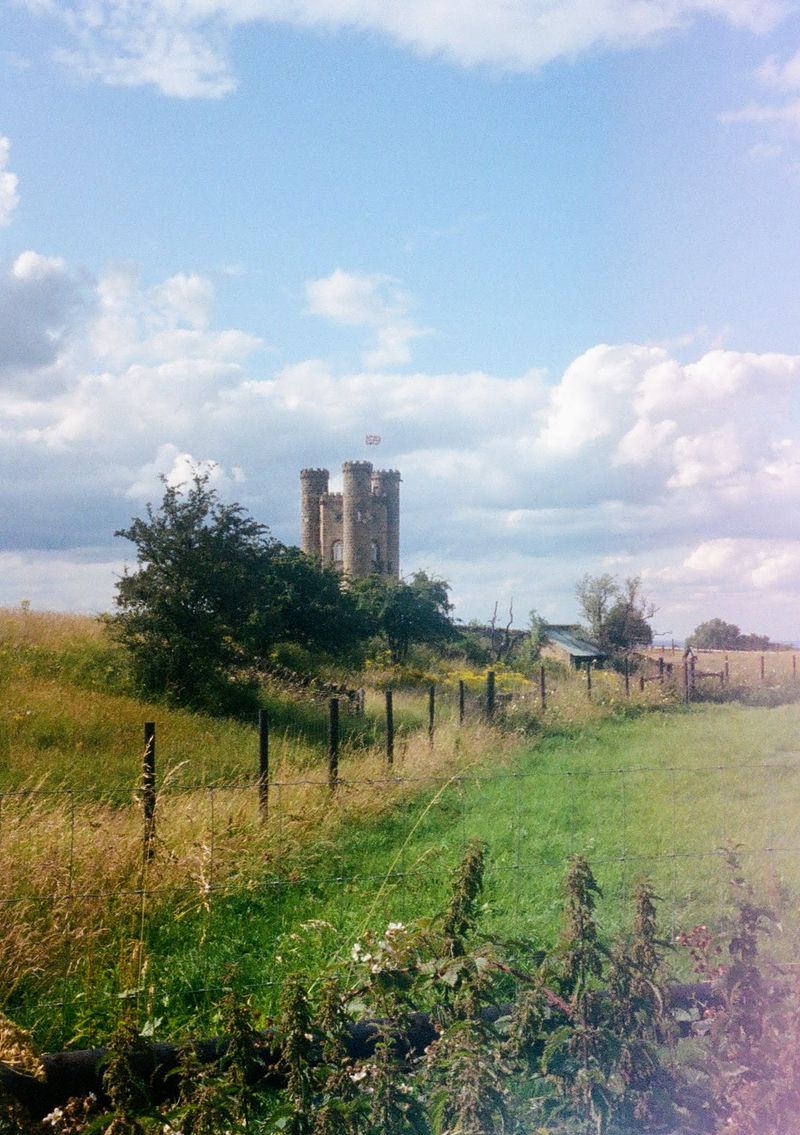 A stone tower stands in a field.