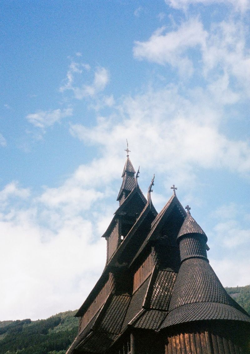 Looking up at the viking style roof of a Stave Church. The entire construction is of dark wood.