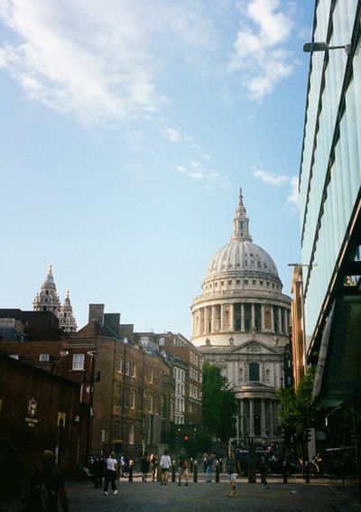 The white dome of St Paul's Cathedral in London rises up between office buildings.